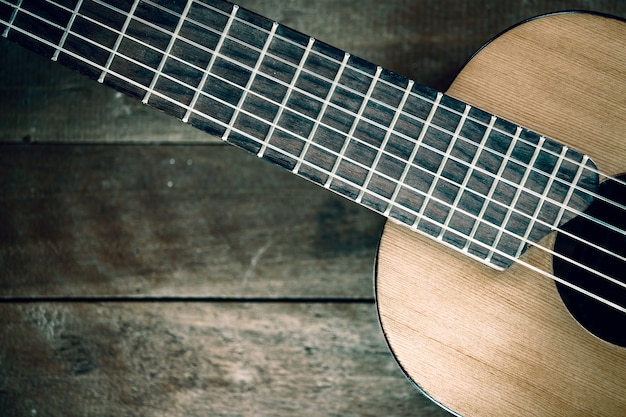 Parte de la guitarra en el fondo de madera