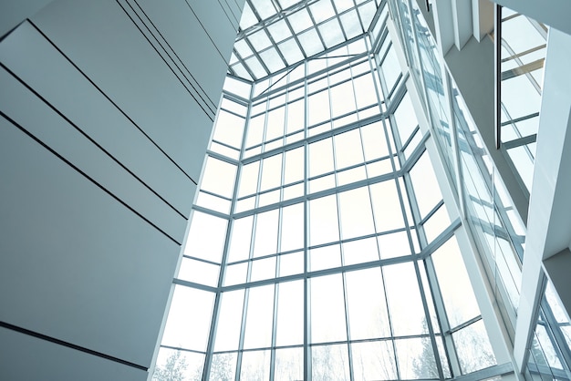 Parte del interior de un gran edificio de oficinas contemporáneo de varios pisos o un centro de negocios con ventanas, paredes y balcones