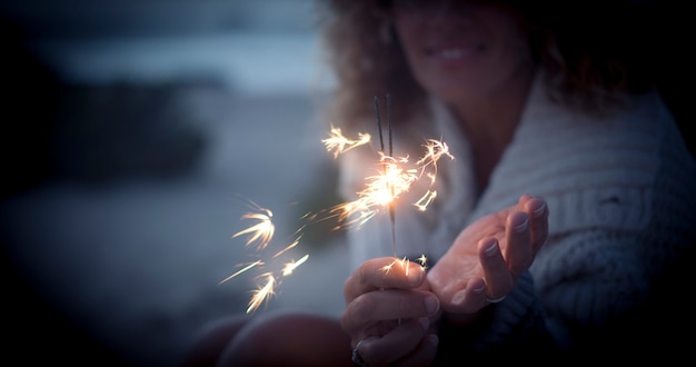 Parte intermediária da mulher com luz cintilante de fogos de artifício