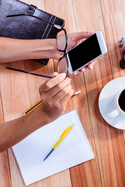 Parte de las manos escribiendo en el teléfono inteligente