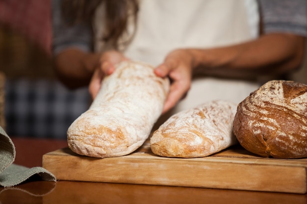 Foto parte mediana de mulher segurando pão no balcão