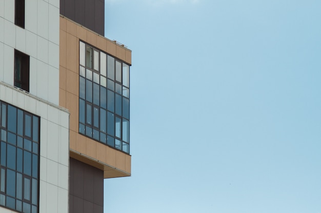 Parte del moderno edificio residencial de apartamentos. Incluyendo un lugar para espacio de copia. Cielo azul con nubes