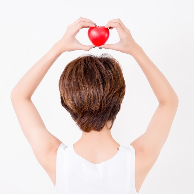 Parte posterior de la hermosa joven asiática con corazón rojo en la cabeza. Concepto para la salud cardiovascular.