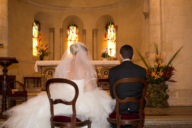 Parte posterior de la novia y el novio en la iglesia durante una ceremonia de boda