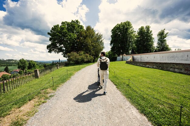 Parte posterior del padre con cochecito de bebé caminando en Chateau Kunstat República Checa