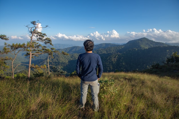 Parte posterior del soporte para hombre feliz en la cima de la montaña, mirando con niebla y nubes a Doi Langka Luang, provincia de Chiang Rai. enfoque suave.