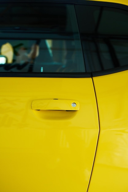 Parte de la puerta y la ventana del coche eléctrico moderno de color amarillo