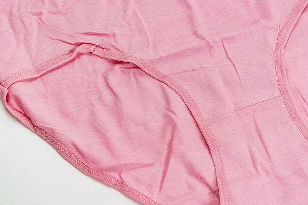 Parte de una ropa interior de algodón rosa sobre un fondo blanco.