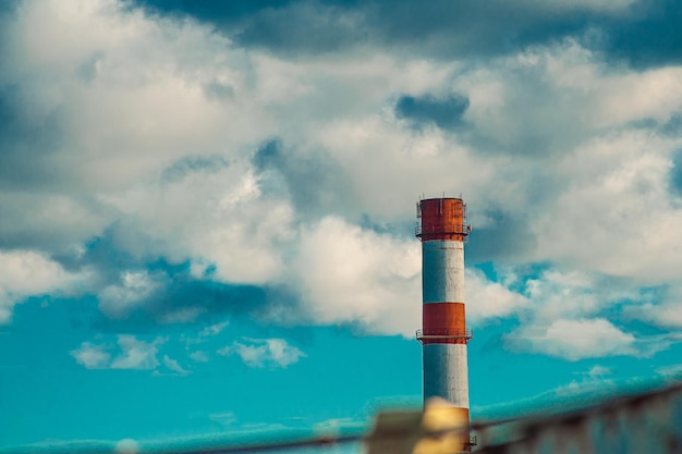 Parte superior do tubo de fumaça industrial contra o fundo do céu azul Tubo de chaminé de fábrica com andaimes de metal Chaminé Tubo de fumaça abandonado feito de tijolo