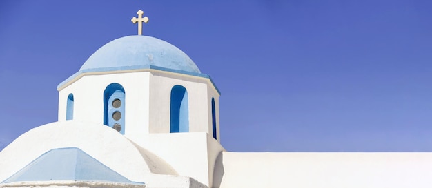 Parte superior de la isla griega de la iglesia ortodoxa edificio encalado de cúpula azul y cruz día soleado Espacio
