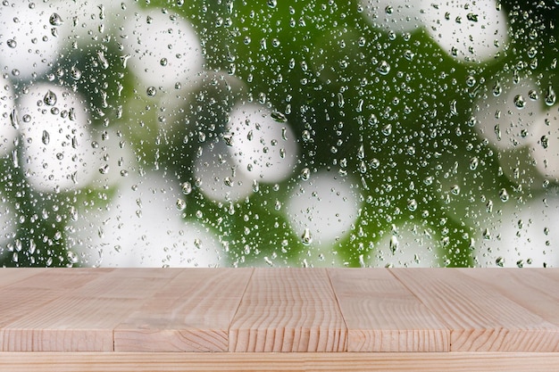 La parte superior de la mesa de madera marrón sobre fondo de gota de agua abstracta bokeh se puede utilizar para el montaje