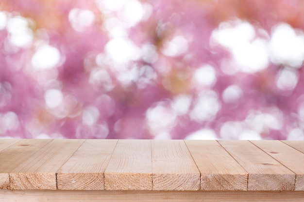 La parte superior de la mesa de madera marrón sobre fondo rosa abstracto bokeh se puede utilizar para el montaje