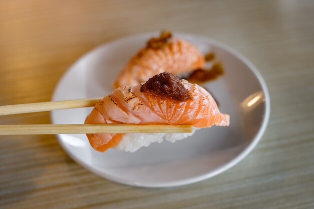 Parte superior de la parrilla de sushi de salmón con miso dulce en palillos