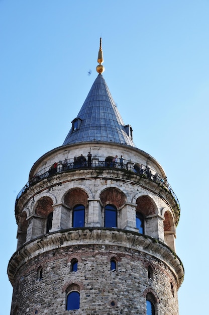 Parte superior de la Torre de Galata contra el cielo azul. Turistas en el mirador de la torre.