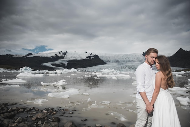 Parte traseira do casal recém-casado caminhando nas planícies da Islândia