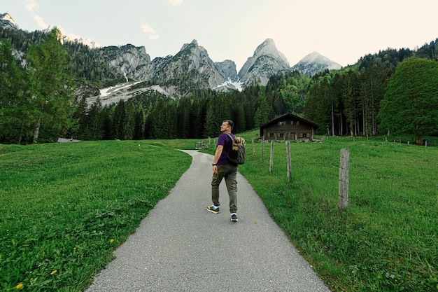 Parte traseira do homem com mochila andando nas montanhas em Vorderer Gosausee Gosau Alta Áustria