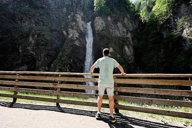 Parte traseira do homem contra a cachoeira em Liechtensteinklamm ou Liechtenstein Gorge Áustria