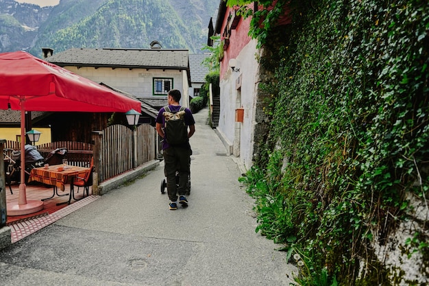 Parte traseira do pai ambulante com carrinho de bebê andando em Hallstatt Áustria