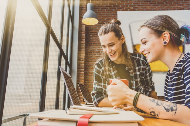 Parte trasera de Hipster joven pareja freelance usando portátil inteligente