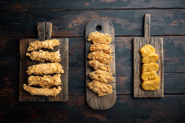Partes de frango frito à milanesa em fundo escuro de madeira