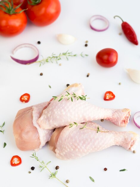 Foto partes de pollo crudo con diferentes ingredientes