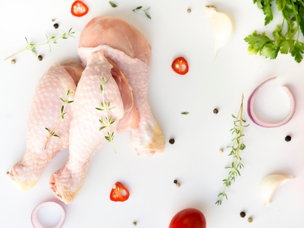 Foto partes de pollo crudo con diferentes ingredientes