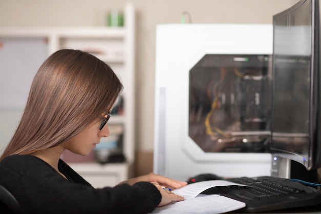 Participa una joven en casa detrás de un monitor de computadora por videoconferencia con libros de texto educativos y cuadernos