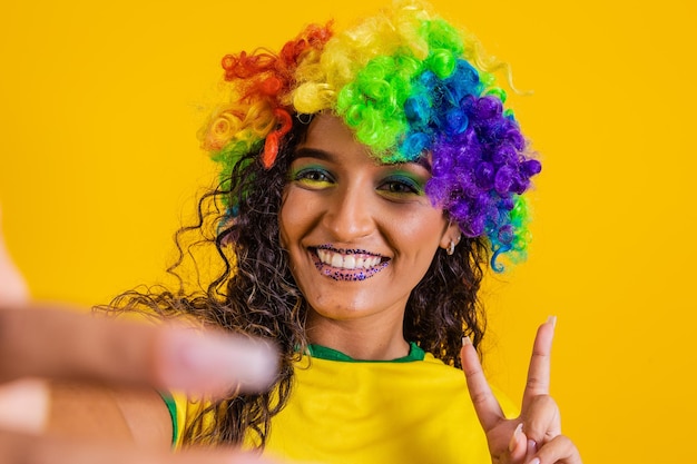 Partidario de Brasil Fan de la mujer brasileña celebrando el partido de fútbol con fondo amarillo Colores de Brasil Selfie