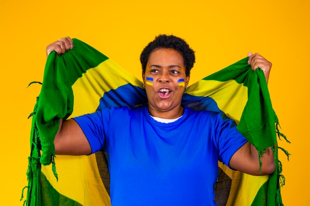 Partidario brasileño Fanático de la mujer brasileña celebrando el fútbol o el partido de fútbol con fondo amarillo Colores de Brasil