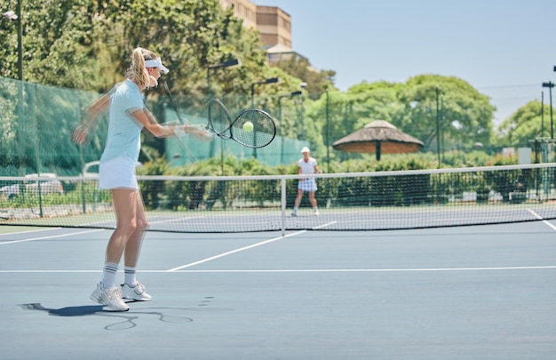 Partido deportivo de cancha de tenis y mujeres al aire libre para ejercicio físico y entrenamiento para la competencia Atleta golpea la pelota en el club para el rendimiento del juego para la salud y el bienestar con acción cardiovascular de verano