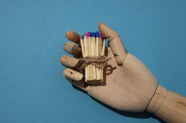 Los partidos con cabezas coloridas están atados con una cuerda en una mano de madera
