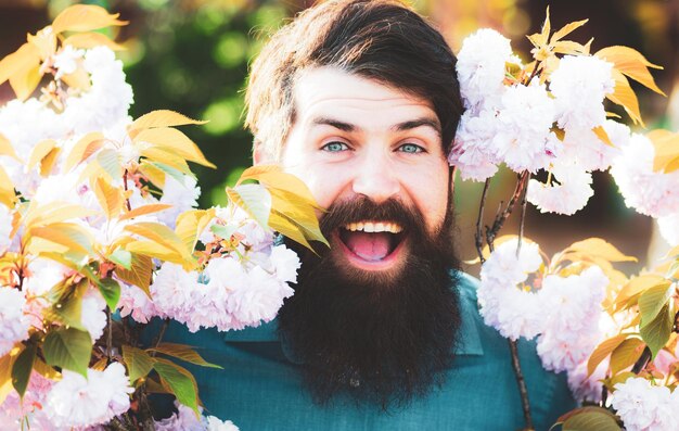 Partrait ao ar livre de jovem cercado por flores flor de primavera