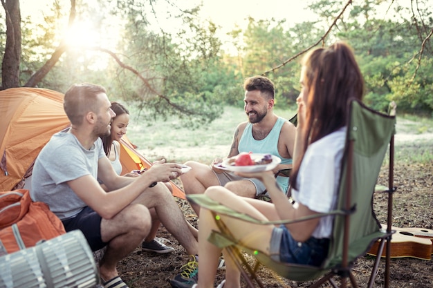 Party, Camping von Männern und Frauen im Wald. Sie entspannen und essen Grill gegen grünes Gras. Der Urlaub, Sommer, Abenteuer, Lifestyle, Picknick-Konzept