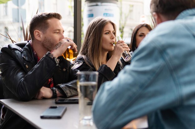 Party- oder Alkoholismus-Konzepte. Eine Gruppe von Freunden trinkt Bier und Cocktails in einer Bar.