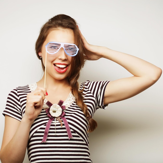 Partybild Verspielte junge Frauen, die eine Partybrille halten Bereit für eine gute Zeit