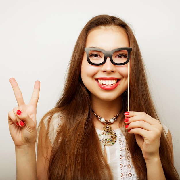 Partybild Verspielte junge Frauen, die eine Partybrille halten Bereit für eine gute Zeit