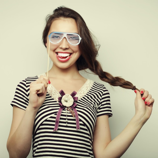 Partybild Verspielte junge Frauen, die eine Partybrille halten Bereit für eine gute Zeit