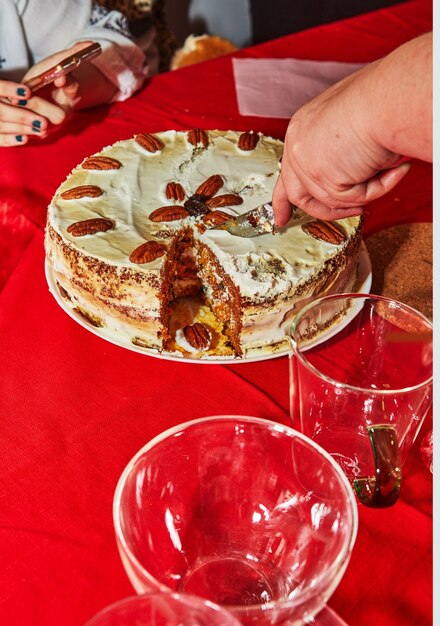 Partykuchen, mit einem messer auf dem tisch in stücke schneiden