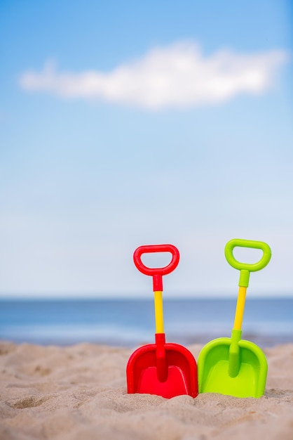 Pás de brinquedo de plástico na praia