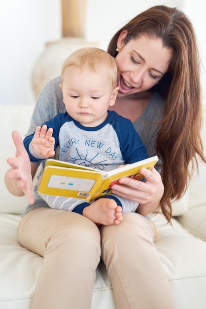 Pasa la página, mamá, y dime qué sucede a continuación. Captura recortada de una madre leyendo un libro a su bebé en casa.