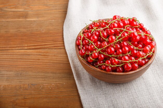 Pasa roja fresca en cuenco de madera en fondo de madera. vista superior