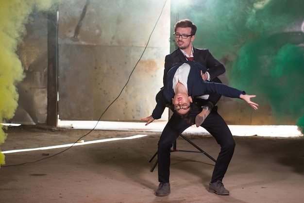 Foto pasadoble, dança solo latina e dança contemporânea - homem e mulher bonitos dançando na nuvem de fumaça.