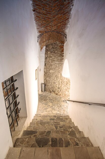 Pasaje entre dos partes del antiguo castillo con una vieja escalera de piedra