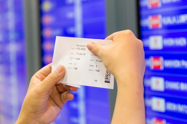 Pasajero en el aeropuerto mira el horario de vuelo