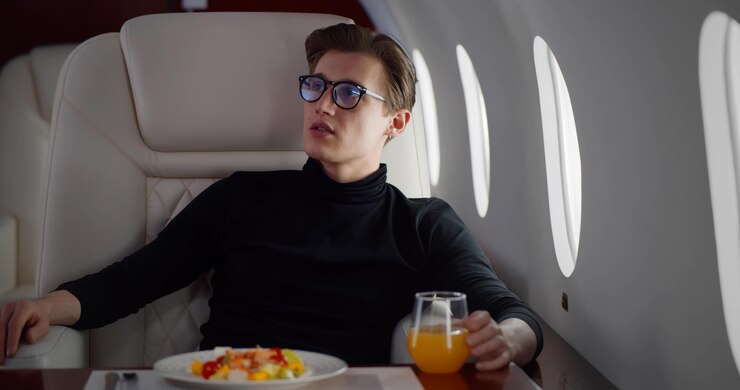 Pasajero masculino comiendo en primera clase