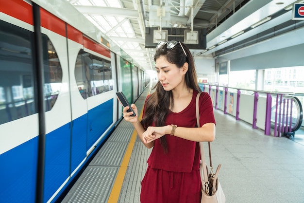 Pasajero de mujer asiática con traje casual mirando el reloj