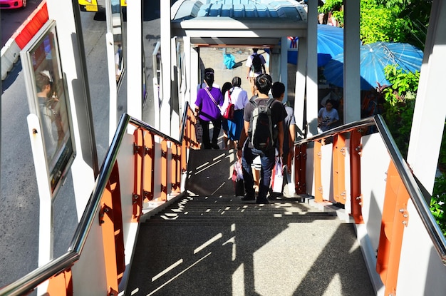 Los pasajeros tailandeses y los viajeros extranjeros que caminan por las escaleras del tren aéreo BTS van a la estación de parada de autobuses para ir al campo rural en Chatuchak el 5 de julio de 2014 en Bangkok, Tailandia