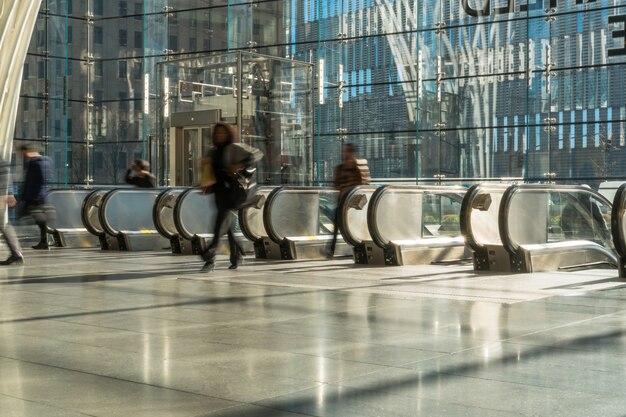 Foto pasajeros y turistas irreconocibles caminando hacia la escalera mecánica