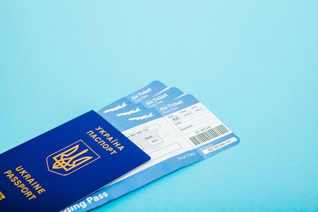 Pasaporte y billetes de avión sobre un fondo azul.