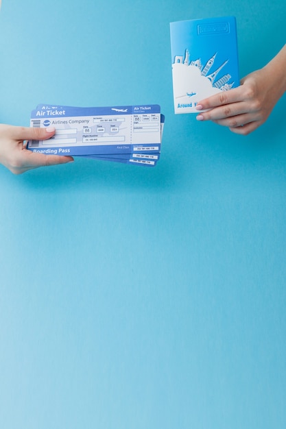 Foto pasaporte y boleto aéreo en mano de mujer.